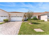 Charming single-story home featuring a red tile roof, brick driveway, and well-manicured lawn with lush landscaping at 2814 Plymouth Pl, Kissimmee, FL 34741