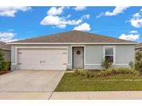 Charming single-story home showcasing a well-manicured lawn, attached garage, and lovely front door with a welcoming wreath at 541 Jerry Ln, Haines City, FL 33844