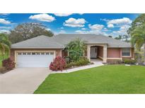 Charming single-story home features lush landscaping, a two-car garage, and a covered front entryway at 6259 Oak Shore Dr, St Cloud, FL 34771