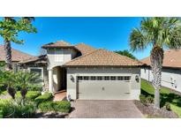 Charming home boasts a clay tile roof, attached two-car garage and neatly landscaped front yard at 1335 Palmetto Dunes St, Davenport, FL 33836