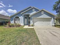 Charming single-story home featuring a well-maintained lawn and a two-car garage at 1361 Rebecca Dr, Haines City, FL 33844