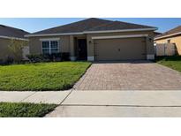 Charming single-story home with a brick paver driveway and well-maintained lawn at 2802 Glendive Dr, Kissimmee, FL 34758