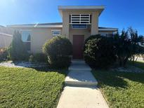 Charming home with landscaped front yard and inviting entrance with concrete walkway at 3100 Rocky River Rd, Kissimmee, FL 34746