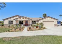 Charming single-story home with a well-manicured lawn, a two-car garage, and lovely landscaping at 3607 Hidden River Ln, Tavares, FL 32778