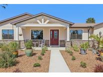 Charming home with a red front door, stone accents, and manicured landscaping at 3607 Hidden River Ln, Tavares, FL 32778