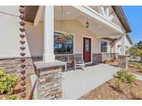 Charming front porch with stone pillars, a hanging plant, and a cozy rocking chair at 3607 Hidden River Ln, Tavares, FL 32778