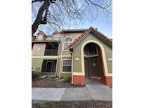 Two-story condo building featuring colorful facades, a red tile roof, and arched entryway at 401 Fountainhead Cir # 155, Kissimmee, FL 34741