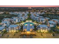 Stunning aerial view of modern community with a large pool and lush landscaping at dusk at 7760 Sandy Ridge Dr # 108, Reunion, FL 34747