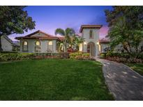 Charming Mediterranean-style home with lush landscaping, a tile roof, and a brick walkway at 8437 Lake Burden Cir, Windermere, FL 34786