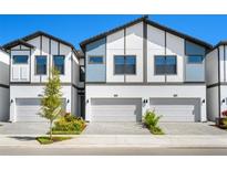 Modern townhome exterior with neutral paint, updated roofing, and private driveways at 10287 Ebb Tide Lane, Orlando, FL 32821