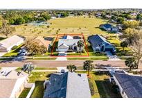 Beautiful home with a two-car garage, surrounded by mature trees and lush landscaping at 16014 Hawk Hill St, Clermont, FL 34714