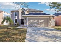 Attractive two-story home with a spacious driveway leading to an attached two-car garage at 16035 Wilkinson Dr, Clermont, FL 34714