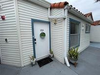 Apartment 203 exterior with potted plants and storm door at 2560 Woodgate Blvd # 203, Orlando, FL 32822