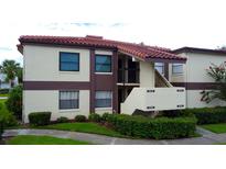 Two story condominium building showing a terracotta roof and lush landscaping at 3214 Candle Ridge Dr # 201, Orlando, FL 32822