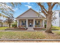 Charming single-story home featuring a welcoming front porch with stately columns and beautiful landscaping at 3317 Schoolhouse Rd, Harmony, FL 34773