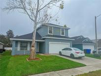 Charming two-story home with a well-manicured lawn and attached two-car garage, perfect for suburban living at 4411 Great Harbor Ln, Kissimmee, FL 34746