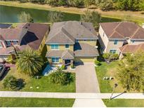 Captivating aerial view of a beautiful home with a brick driveway, lush lawn, and picturesque surroundings at 4842 Rockvale Dr, Kissimmee, FL 34758