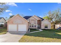 Charming brick home with well-manicured lawn, driveway and 2-car garage at 673 Leland Dr, Deltona, FL 32725