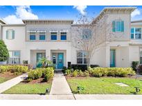 Charming townhome showcases a well-manicured lawn, walkway and vibrant turquoise-colored doors at 8968 Amelia Downs Trl, Kissimmee, FL 34747