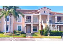 Inviting two-story condo with lush landscaping, mature palm trees, and reserved parking at 13840 Timberbrooke Dr # 103, Orlando, FL 32824