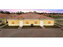 Charming single-story villa with red tile roof, yellow exterior, and well manicured landscaping at 1787 Coriander Dr, Kissimmee, FL 34759