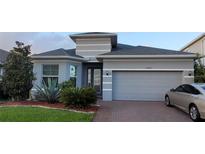 Beautifully landscaped single-Gathering home with a brick-paved driveway and a two-car garage at 17880 Passionflower Cir, Clermont, FL 34714