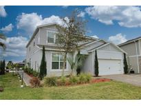 Charming two-story home showcasing landscaped front yard, attached two-car garage, and craftsman design details at 3262 Hanging Tide St, Winter Garden, FL 34787