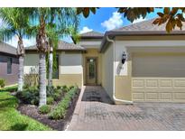 Well-maintained single-story home featuring a brick driveway and meticulously landscaped front yard at 514 Cadiz Dr, Davenport, FL 33837