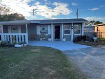 Charming single-story home with a quaint front porch and well-maintained lawn at 7624 Udine Ave, Orlando, FL 32819
