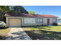 Charming single-story home featuring a front yard, driveway, and attached one-car garage at 100 Avenue K Ne, Winter Haven, FL 33881
