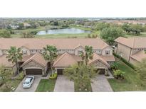 Beautiful townhome with tile roof, two-car garage, brick driveway, and views of the golf course and pond at 10731 Belfry Cir, Orlando, FL 32832