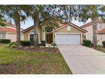 Charming one-story home featuring a red tile roof, well-manicured lawn, and a two-car garage at 113 Cordova Ave, Davenport, FL 33897