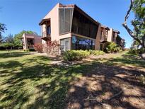 Charming condo exterior featuring a screened-in porch and well-maintained landscaping, perfect for outdoor living at 133 La Casa # 133, Lake Wales, FL 33898