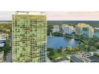 Luxury high-rise exterior with city views, lush trees and a large lake on a sunny day at 150 E Robinson St # 219, Orlando, FL 32801