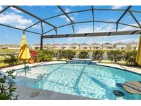 Gorgeous screened-in pool with a waterfall feature, lush landscaping, and stunning water views at 1565 Leaf Ln, Kissimmee, FL 34744