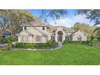 Charming traditional-style home featuring a well-manicured lawn and a welcoming front entrance with decorative windows at 2515 Ridgewind Way, Windermere, FL 34786