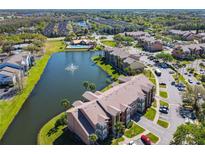 Beautiful aerial view of the community with a scenic pond, fountain, pool and well-maintained landscaping at 4105 Tropical Isle Blvd # 222, Kissimmee, FL 34741