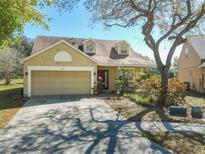 Charming home featuring a well-manicured front yard with mature trees and a two-car garage at 4331 Willowcrest Ct, Orlando, FL 32826