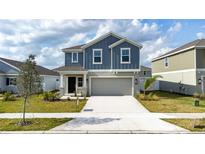 Charming two-story home featuring a covered entry, two-car garage, and beautifully landscaped front yard at 606 Bell Prairie Cir, Lake Wales, FL 33859