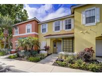 Charming townhome featuring vibrant colors, manicured landscaping, and a welcoming entrance at 8517 Crystal Cove Loop, Kissimmee, FL 34747
