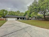 Charming single-story home featuring an attached garage, a spacious driveway, and a well-maintained lawn at 876 Lobster Ct, Kissimmee, FL 34744