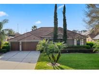 Beautiful home featuring a large garage, lush landscaping, and a well-maintained lawn at 10986 Ledgement Ln, Windermere, FL 34786