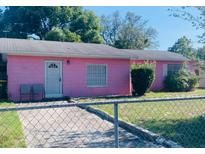 Charming single-story home with a pink exterior and a well-maintained front yard at 205 Elinor S Ave, Dundee, FL 33838