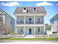 Charming two-story home with a double porch and white picket fence, creating a welcoming curb appeal at 205 Norfolk Pl, Celebration, FL 34747