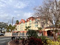 Attractive exterior of the hotel on a sunny day with lovely landscaping and mature trees at 3000 Maingate Ln # 330, Kissimmee, FL 34747