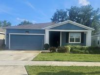 Charming single-story home featuring a well-manicured lawn and an attached two-car garage at 4497 Bluff Oak Loop, Kissimmee, FL 34746