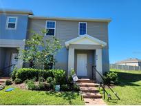 Charming two-story home with landscaped yard, brick pathway, and covered entrance at 474 Annabelle Way, Davenport, FL 33837