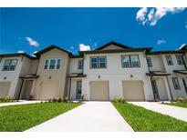 Beautiful townhomes showcasing modern architecture, complemented by lush green lawns and blue skies at 947 Conch Rd, Davenport, FL 33896