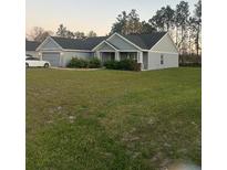 Charming single-story home with a well-manicured lawn, attached garage, and inviting covered entry at 11115 Sw 54Th Cir, Ocala, FL 34476