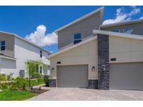 Modern home exterior showcasing clean lines, neutral colors, and attached garages with a well-maintained front yard at 1137 Drop Ln # 1137, Davenport, FL 33896